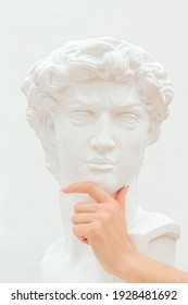 Women's hand holds a chin of the plastic sculpture of a man.Emotions, thoughtfulness,
creative concept. - Shutterstock ID 1928481692