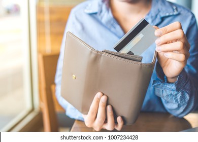 Women's Hand Using A Credit Card, She Pulled The Card Out Of Her Wallet.