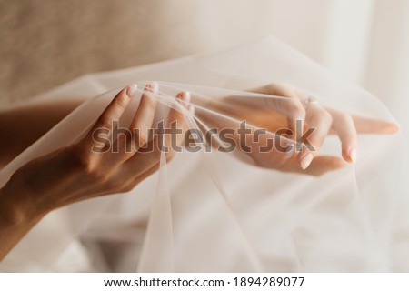 women's hands of the bride under the veil. Tenderness. wedding photo shoot. advertising of hand-care products.
