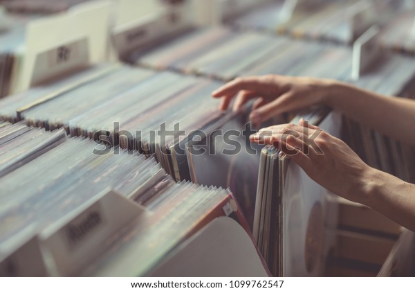 Women\'s\
hands browsing records in a vinyl record\
store