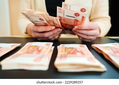 women's hands count a stack of money of a banknotes of 5000 rubles on a black background. the concept of depreciation of the ruble. earnings online in Russia.