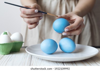 Women's hands decorate boiled eggs for easter. High quality photo