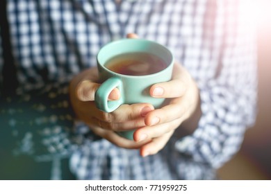 Women's hands hold a cup of tea, toning