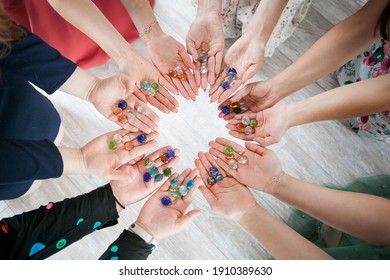 women's hands hold stones in a circle. unity, cohesion