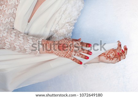 Women's hands hold a white handkerchief. Drawing of henna on hands. Body art