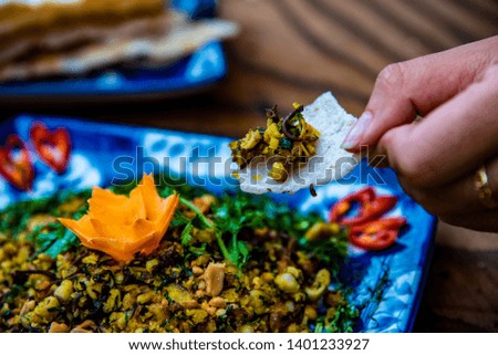 Women's hands holding baby clams with rice crackers, they are decorated on wooden table  - specialty food at  Da Nang, Viet Nam