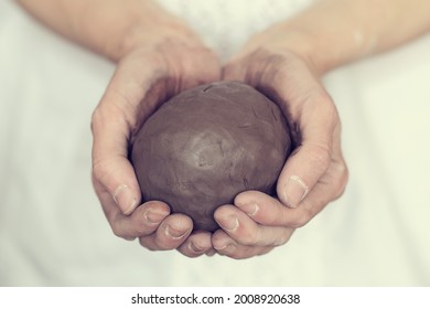 women's hands holding a grey ball. Prepare to work in a pottery workshop. Pottery made of clay with their own hands. - Powered by Shutterstock