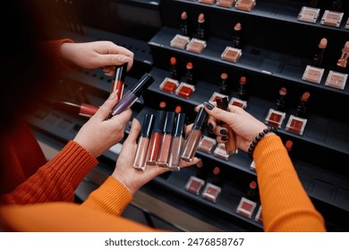 Womens hands holding lipsticks different colors in cosmetics shop - Powered by Shutterstock