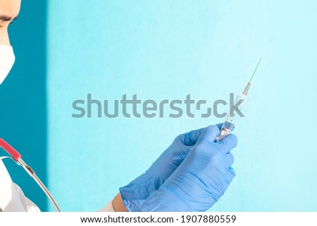 women's hands in latex gloves hold a syringe. Medical concept