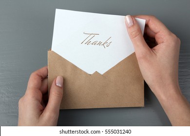 Women's hands with a letter in his hand with the words thank you