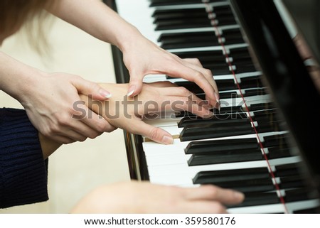 Women's hands on the keyboard of piano. girl plays. music teacher