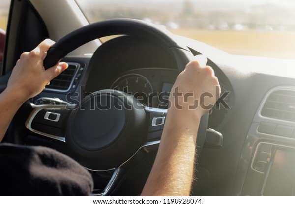 Women\'s hands\
on the steering wheel of the car. Concept woman driving,feminism,\
freedom and\
independence