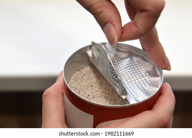 Women's Hands Opening The Lid Of A Jar Of Instant Coffee With Milk