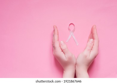 Women's Hands With A Pink Ribbon Symbol Of The Fight Against Breast Cancer.