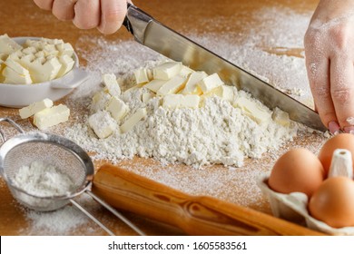 Women's hands prepare doughy. Ingredients on a wooden table-wheat flour, butter or margarine, eggs, salt, sugar, milk. Selective focus - Shutterstock ID 1605583561