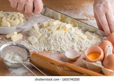 Women's hands prepare doughy. Ingredients on a wooden table-wheat flour, butter or margarine, eggs, salt, sugar, milk. Selective focus - Shutterstock ID 1605740200