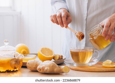 Women's hands prepare hot drink tea from ginger root lemon honey for cold treatment and prevention - Powered by Shutterstock