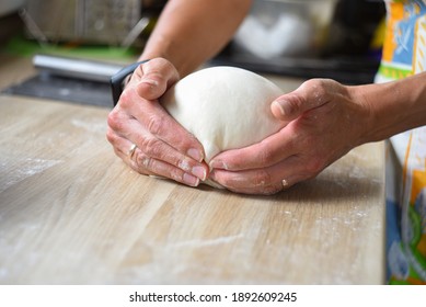 women's hands from raw dough make a ball for baking bread in the home kitchen - Powered by Shutterstock