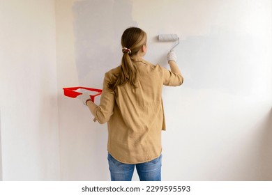 Womens hands using paint roller while working indoors. - Powered by Shutterstock