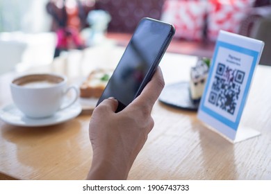 Las manos de las mujeres están usando el teléfono para escanear el código qr para seleccionar el menú de comida. Escanear para obtener descuentos o pagar por comida. El concepto de usar un teléfono para transferir dinero o pagar dinero en línea sin efectivo.