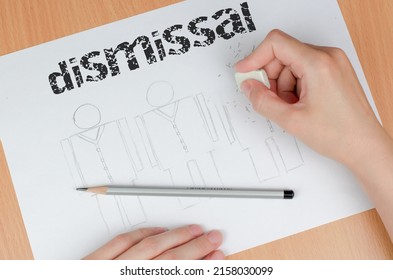 Women's Hands Wipe A Person Drawn With A Pencil With An Eraser. The Concept Of Dismissal Or Downsizing. Erasing A Drawn Person From Paper