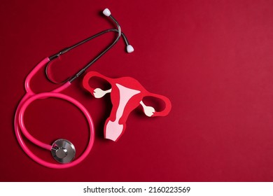 Women's Health Awareness Concept. Uterus Symbol With Stethoscope On Red Background. Diagnostic And Research Women's Reproductive System.