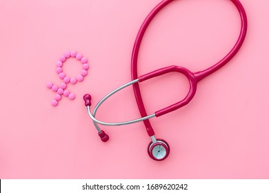 Women's Health issues. Medical concept with Venus sign and stethoscope on pink background top-down