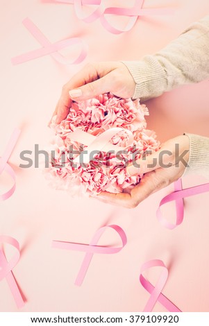 Womens health symbol in pink ribbon on wooden board.