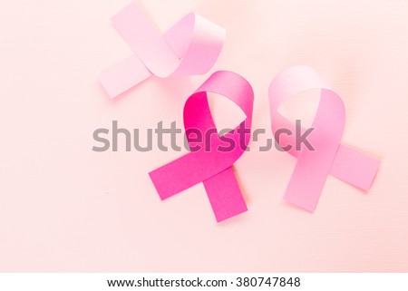 Womens health symbol in pink ribbon on a pink background.