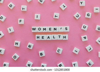 Women's Health word made of square letter word on pink background.