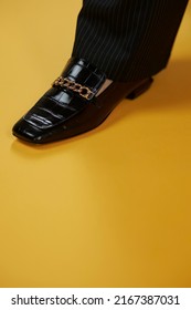 Women's Lacquered Black Loafers Close-up On A Yellow Background. Women's Loafers. Style And Fashion