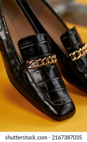 Women's Lacquered Black Loafers Close-up On A Yellow Background. Women's Loafers. Style And Fashion