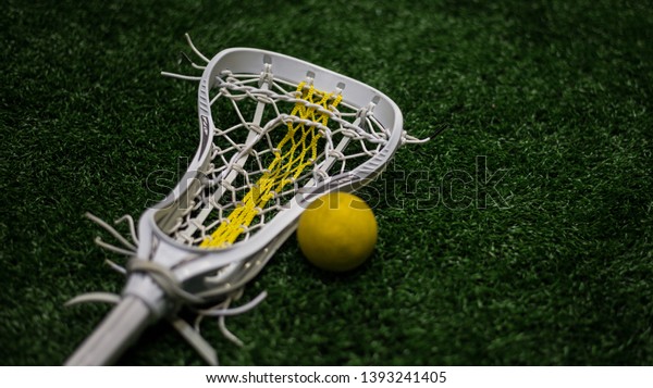 Women\'s\
lacrosse stick next to yellow lacrosse balls.\

