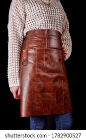 Women's Leather Apron, On A Girl, In A Knitted Sweater And Jeans, No Face. On Black