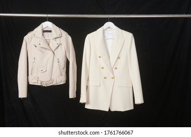 Women's Leather Jacket And Formal Business  White Suit On Hanger-black Background
