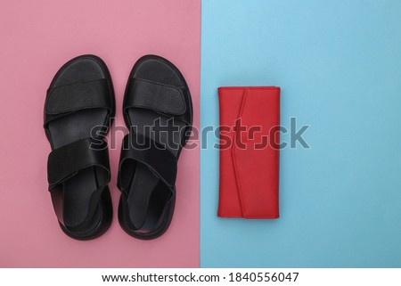 Women's leather sandals and leather wallet on a pink-blue pastel background. Women's accessories. Top view. Flat lay