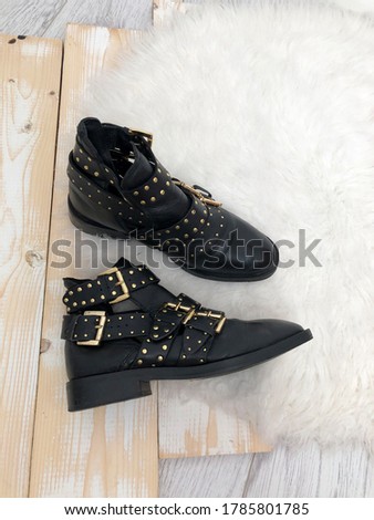 Women's leather shoes with golden buckles on a white wooden background