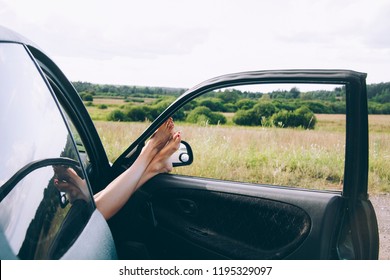 Women's legs in the car window