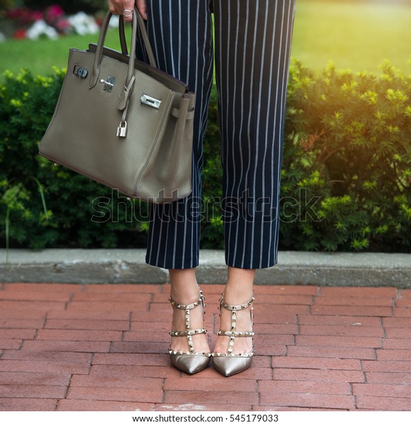灰色のハイヒールの女性の脚 灰色の靴 袋 青いズボン 綿パンツ スタイリッシュなレディーシューズ バッグ ビジネスマンのオフィス服 通りのスタイル ビジネスカジュアルな外観 夏の服 の写真素材 今すぐ編集