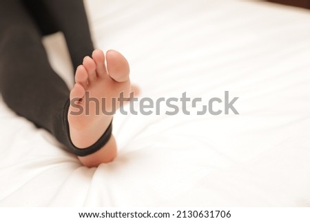 Women's legs in leggings on the bed.