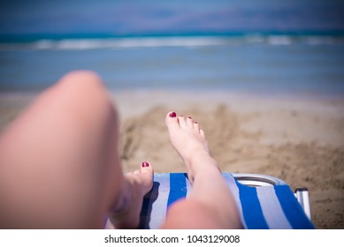 Womens Legs On A Sun Bed Point Of View Shot Sunny Day On The Beach Painted Nails