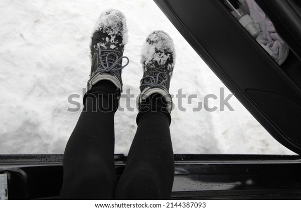 Women\'s legs shake off snow boots when boarding a\
car POV view