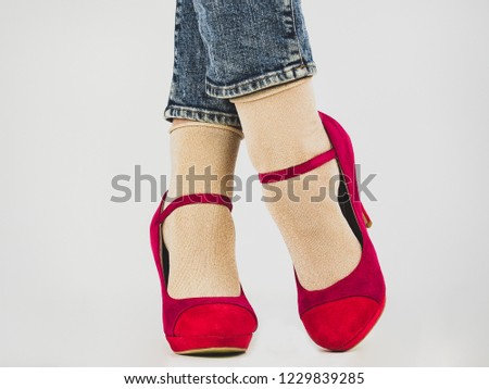 Women's legs in stylish, pink shoes. White background, isolated, close-up. Сoncept of fashion and elegance