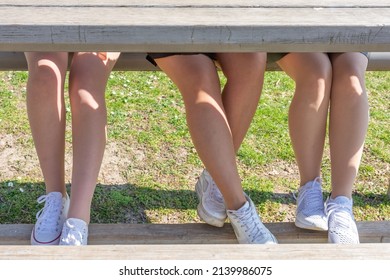 womens legs under a wooden table in nature in spring
