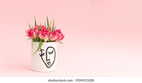 Womens Mental Health Concept. Bouquet Of Pink Tulips In A White Vase With Women Face. Pink Background.