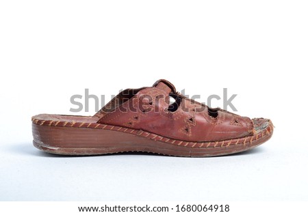 Women's old brown leather summer sandal isolated on a light background. 