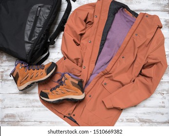 Womens outwear, footwear (brown trench jacket, shuede hiking boots), backpack.  Outfit for traveling. Autumn winter collection. Fashion Shopping concept. Flat lay, view from above