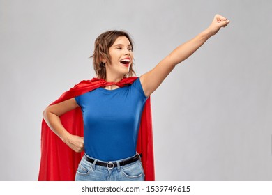 Women's Power And People Concept - Happy Woman In Red Superhero Cape Making Flying Pose Over Grey Background