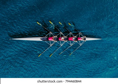 Equipo femenino de remo en agua azul, vista superior