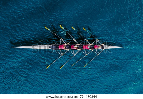 Women\'s rowing team\
on blue water, top view